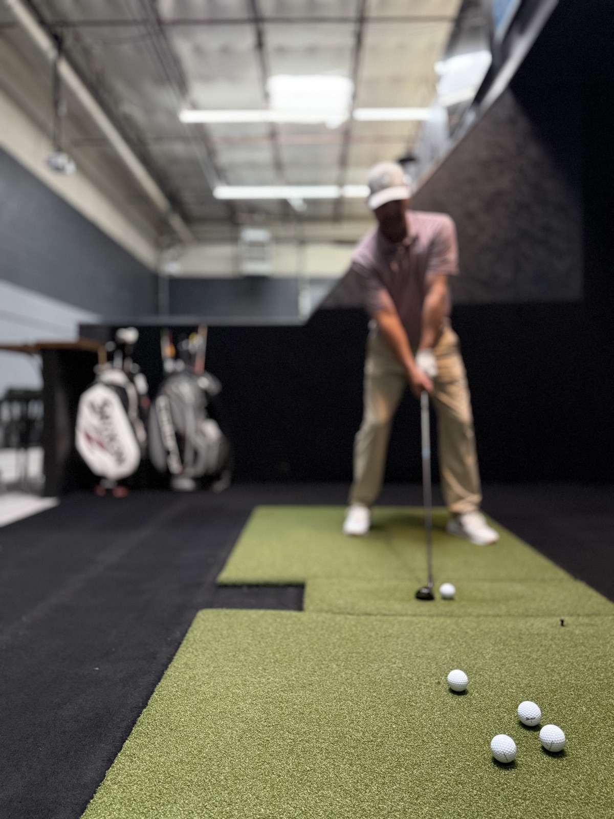 Hitting balls on a Uneekor simulator bay at COR Golf