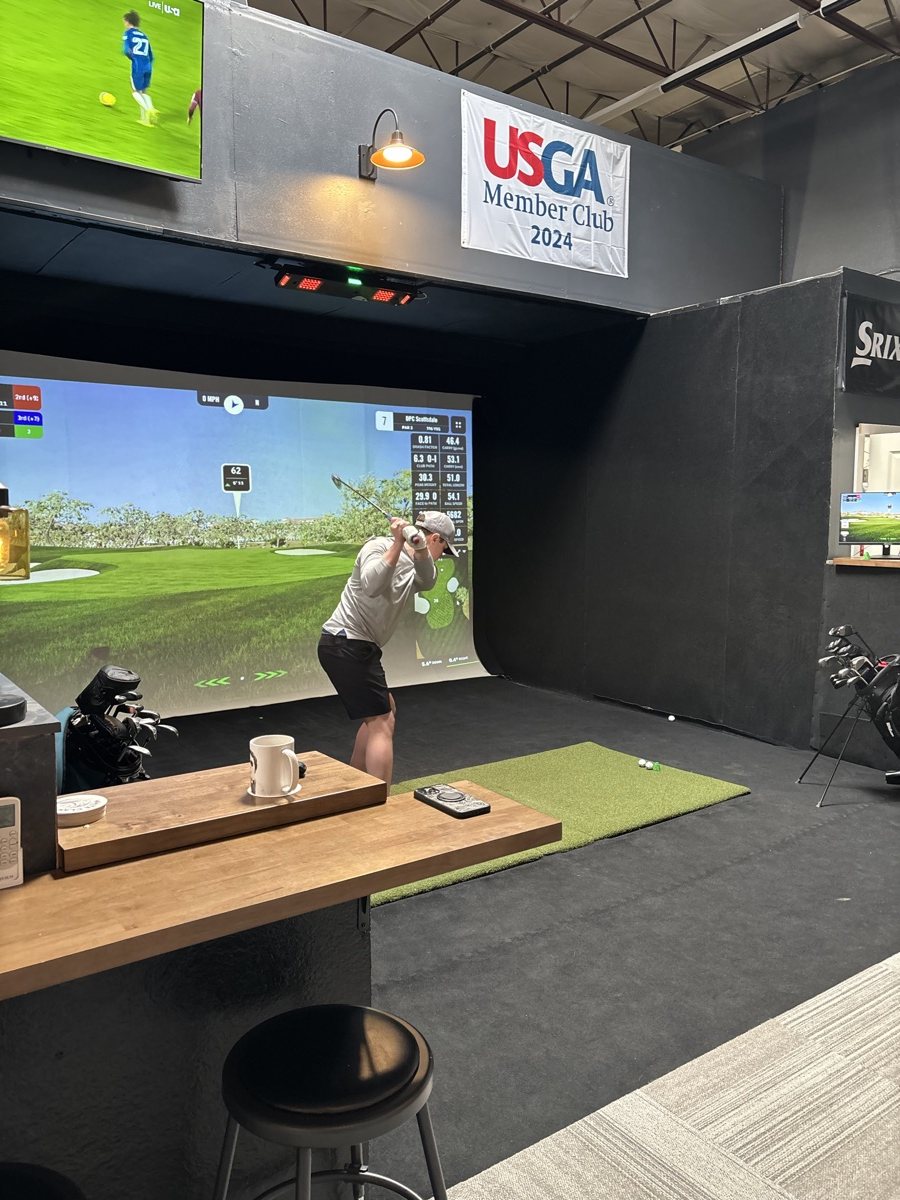 View from the COR Golf café counter into a simulator bay