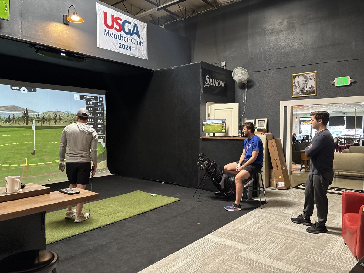 Players watching a league round on a COR Golf simulator bay