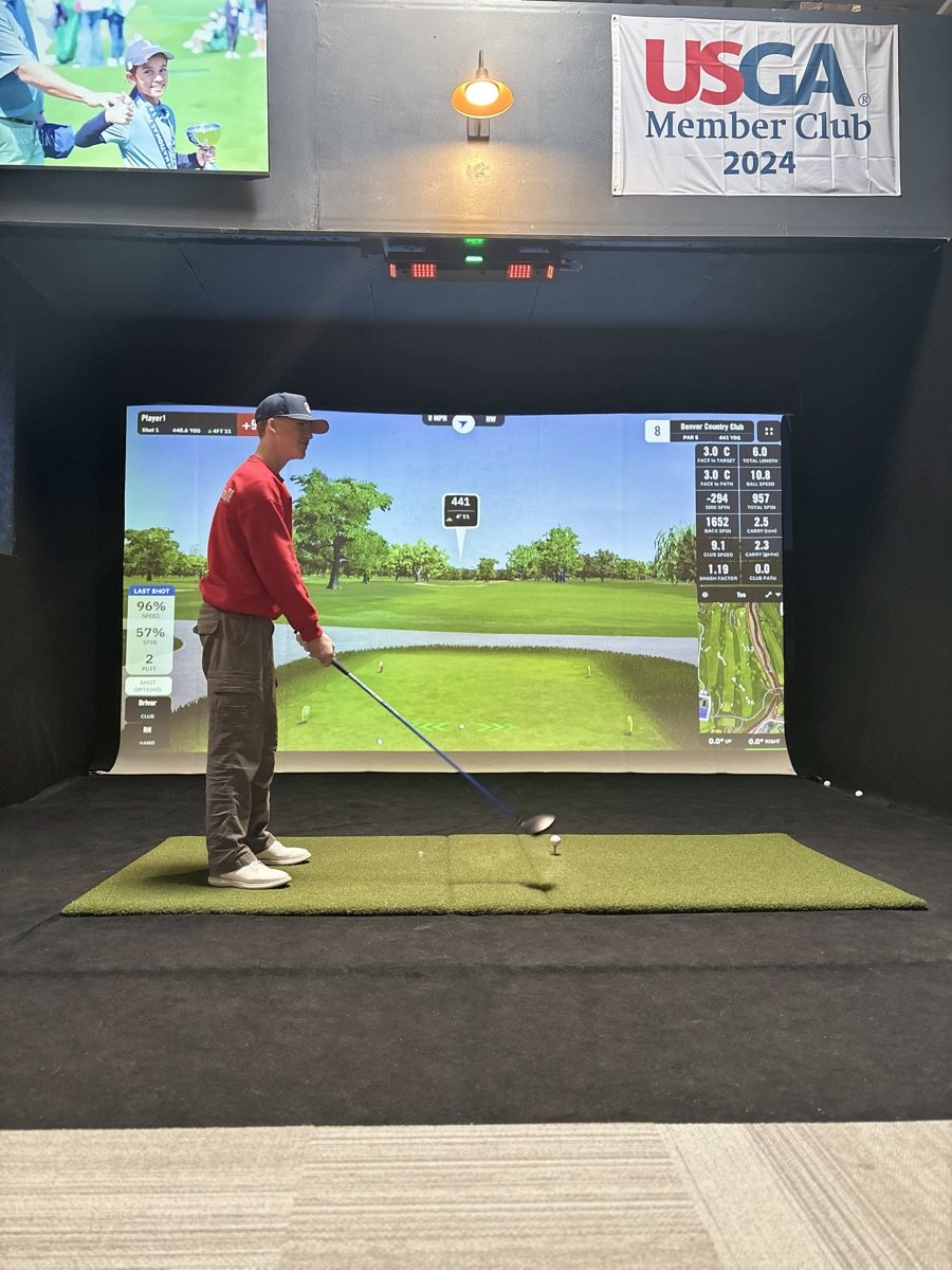 Student hitting on a simulator bay during a lesson at COR Golf