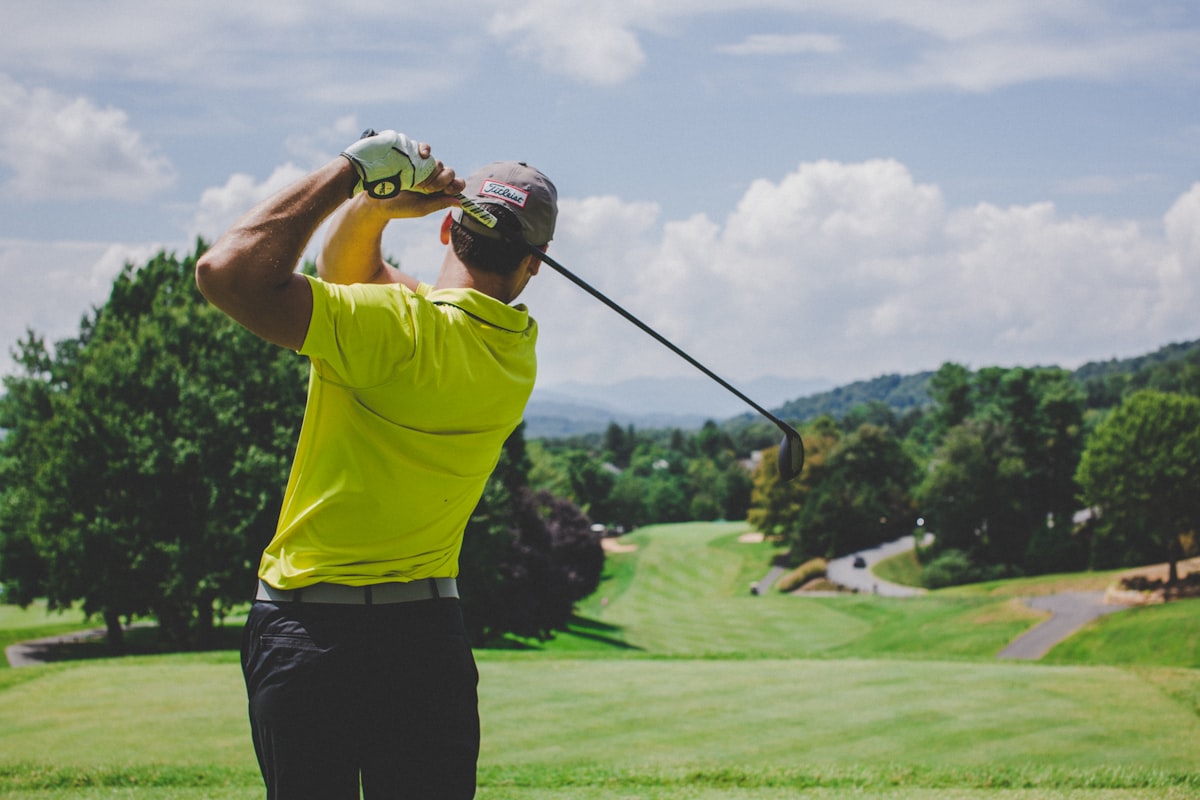 Golfer mid-swing — unwind in the lounge after your round